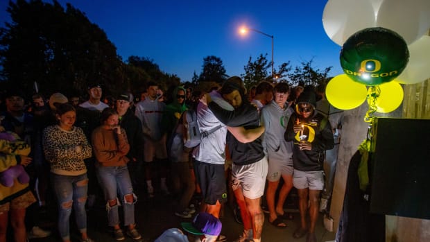 People leave candles at the entrance to Autzen Stadium during a candlelight vigil in remembrance of tight end Spencer Webb