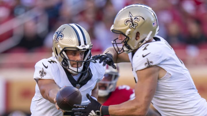 August 18, 2024; Santa Clara, California, USA; New Orleans Saints quarterback Derek Carr (4) hands the football off to quarterback Taysom Hill (7) during the first quarter against the San Francisco 49ers at Levi's Stadium. Mandatory Credit: Kyle Terada-USA TODAY Sports