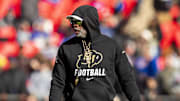 Nov 23, 2024; Kansas City, Missouri, USA;  Colorado head coach Deion Sanders watches his players warmup prior to the game between the Kansas Jayhawks and the Colorado Buffaloes at GEHA Field at Arrowhead Stadium. 