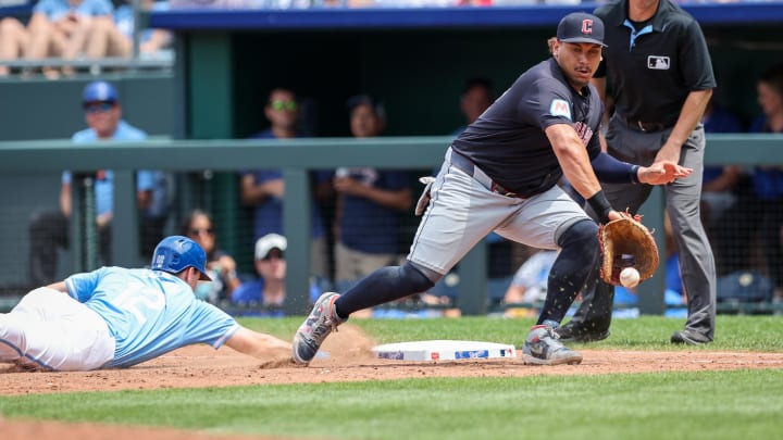 Jun 30, 2024; Kansas City, Missouri, USA; Cleveland Guardians first base Josh Naylor (22) reaches for a throw as Kansas City Royals second base Nick Loftin (12) dives back to first base during the sixth inning at Kauffman Stadium. Mandatory Credit: William Purnell-USA TODAY Sports