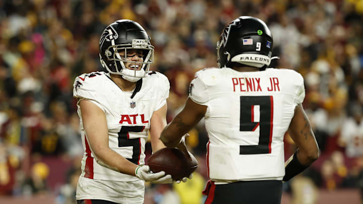 Atlanta Falcons wide receiver Drake London hands the ball to Falcons quarterback Michael Penix Jr. 