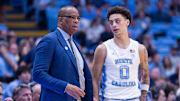 Nov 18, 2025; Chapel Hill, North Carolina, USA; North Carolina Tar Heels head coach Hubert Davis talks to guard Kyan Evans (0) during the second half against the Navy Midshipmen at Dean E. Smith Center. Mandatory Credit: Scott Kinser-Imagn Images