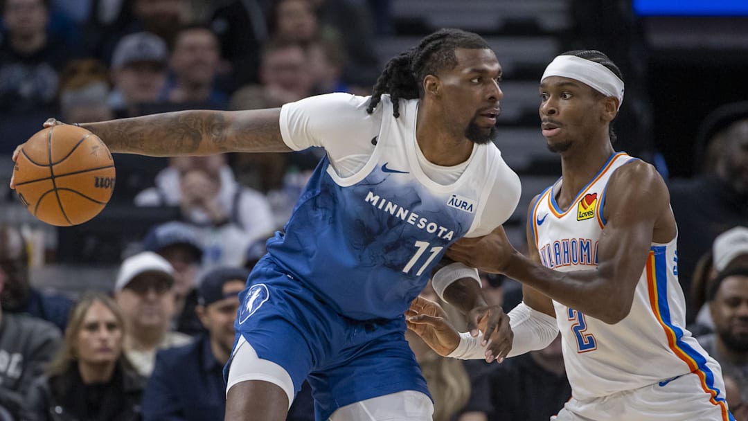Jan 20, 2024; Minneapolis, Minnesota, USA; Minnesota Timberwolves center Naz Reid (11) backs towards the basket as Oklahoma City Thunder guard Shai Gilgeous-Alexander (2) plays defense in the first half at Target Center. Mandatory Credit: Jesse Johnson-Imagn Images