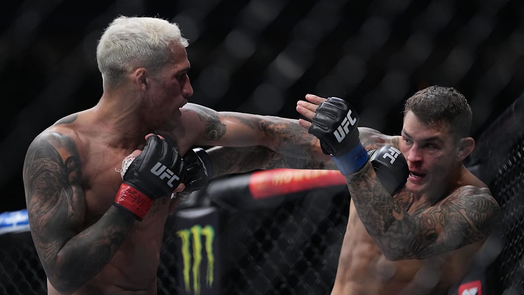 Dec 11, 2021; Las Vegas, Nevada, USA; Charles Oliveira moves in with a hit against Dustin Poirier during UFC 269 at T-Mobile Arena. Mandatory Credit: Stephen R. Sylvanie-Imagn Images