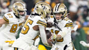 Dec 23, 2024; Green Bay, Wisconsin, USA;  New Orleans Saints quarterback Spencer Rattler (18) hands the football off to running back Kendre Miller (25) during the third quarter against the Green Bay Packers at Lambeau Field. Mandatory Credit: Jeff Hanisch-Imagn Images