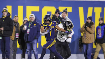Nov 23, 2024; Morgantown, West Virginia, USA; West Virginia Mountaineers running back Jahiem White (1) runs the ball against the UCF Knights during the third quarter at Mountaineer Field at Milan Puskar Stadium. Mandatory Credit: Ben Queen-Imagn Images