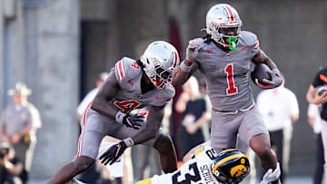 Iowa Hawkeyes defensive back Quinn Schulte tackles Ohio State Buckeyes running back Quinshon Judkins.