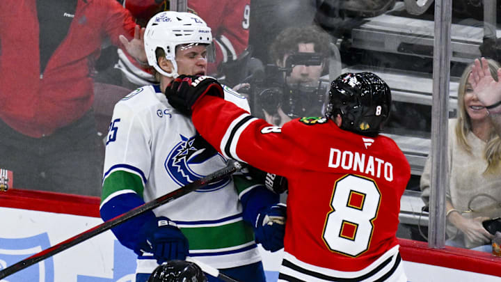Oct 17, 2025; Chicago, Illinois, USA;  Chicago Blackhawks center Ryan Donato (8) punches Vancouver Canucks defenseman Elias Pettersson (25) during the second period at the United Center. Mandatory Credit: Matt Marton-Imagn Images