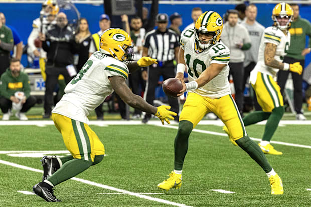 Green Bay Packers quarterback Jordan Love (10) hands the ball off to running back Josh Jacobs