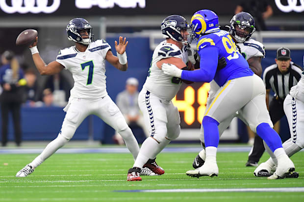 Seattle Seahawks QB Geno Smith throws as guard Austin Blythe provides coverage against Rams defensive tackle Bobby Brown III
