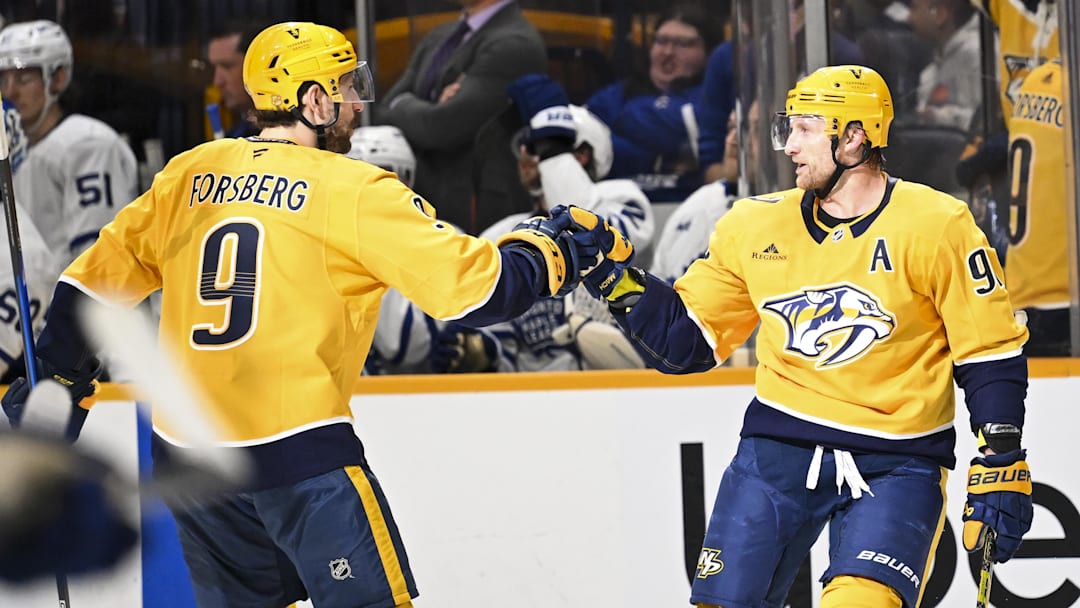 Dec 20, 2025; Nashville, Tennessee, USA;  Nashville Predators center Steven Stamkos (91) celebrates a goal with left wing Filip Forsberg (9) against the Toronto Maple Leafs during the third period at Bridgestone Arena. Mandatory Credit: Steve Roberts-Imagn Images