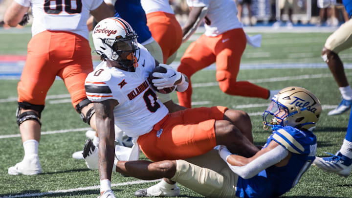 Sep 14, 2024; Tulsa, Oklahoma, USA;  Tulsa Golden Hurricane safety Devin Robinson (16) tackles Oklahoma State Cowboys running back Ollie Gordon II (0) during a game at Skelly Field at H.A. Chapman Stadium. Mandatory Credit: Brett Rojo-Imagn Images