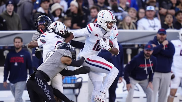Nov 1, 2025; Boulder, Colorado, USA; Arizona Wildcats wide receiver Tre Spivey (12) runs for a touchdown past the tackle of Colorado Buffaloes defensive back Tawfiq Byard (7) in the first quarter at Folsom Field. Mandatory Credit: Ron Chenoy-Imagn Images