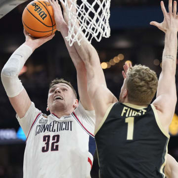 Connecticut Huskies center Donovan Clingan (32) shoots while being guarded by Purdue Boilermakers forward Caleb Furst (1) during the Men's NCAA national championship game at State Farm Stadium in Glendale on April 8, 2024.