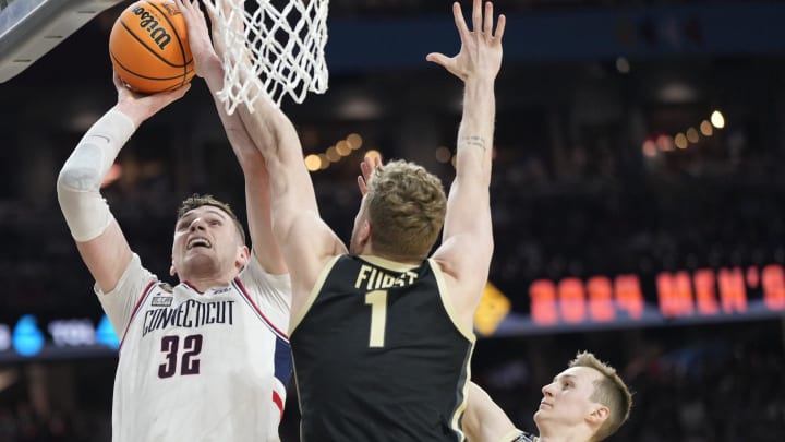 Connecticut Huskies center Donovan Clingan (32) shoots while being guarded by Purdue Boilermakers forward Caleb Furst (1) during the Men's NCAA national championship game at State Farm Stadium in Glendale on April 8, 2024.