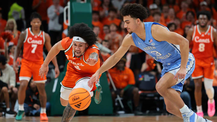 Feb 10, 2026; Coral Gables, Florida, USA; Miami Hurricanes guard Tre Donaldson (3) and North Carolina Tar Heels guard Derek Dixon (3) reach for a loose ball during the first half at Watsco Center. Mandatory Credit: Sam Navarro-Imagn Images