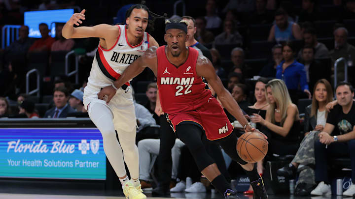 Jan 21, 2025; Miami, Florida, USA; Miami Heat forward Jimmy Butler (22) drives to the basket past Portland Trail Blazers guard Dalano Banton (5) during the first quarter at Kaseya Center. Mandatory Credit: Sam Navarro-Imagn Images