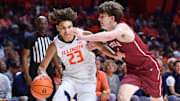 Nov 14, 2025; Champaign, Illinois, USA;  Illinois Fighting Illini guard Keaton Wagler (23) drives the ball against Colgate Raiders guard Ben Tweedy (6) during the first half at State Farm Center. Mandatory Credit: Ron Johnson-Imagn Images