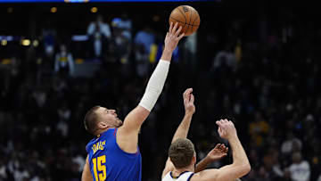 Jan 23, 2025; Denver, Colorado, USA; Sacramento Kings forward Domantas Sabonis (11) and Denver Nuggets center Nikola Jokic (15) reach for the tip off n the first quarter at Ball Arena. Mandatory Credit: Ron Chenoy-Imagn Images