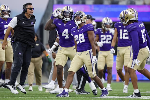 Washington Huskies linebacker Khmori House (28) celebrates with safety Justin Harrington (4) following an interception agains