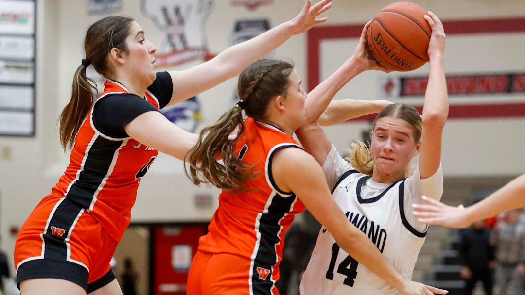 Shawano High School senior Leah Nordin (14) fights to maintain possession versus West De Pere's Mia Racine (4) and Alexa Rattray (1) in a game on Tuesday, January 28, 2025.