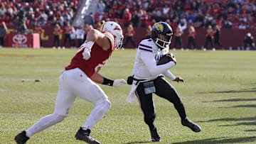Nov 22, 2025; Ames, Iowa, USA; Kansas Jayhawks quarterback Jalon Daniels (6) is pursued by Iowa State Cyclones linebacker Caleb Bacon (26) during the second half at Jack Trice Stadium. Mandatory Credit: Reese Strickland-Imagn Images