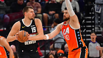 Nov 12, 2025; Inglewood, California, USA; Denver Nuggets center Nikola Jokic (15) controls the ball against Los Angeles Clippers center Ivica Zubac (40) during the first half at Intuit Dome. Mandatory Credit: Gary A. Vasquez-Imagn Images