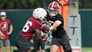 July 30, 2025; Tuscaloosa, AL, USA; Quarterback Ty Simpson hands off to running back Jam Miller during the first practice session of the preseason for the Alabama Crimson Tide.