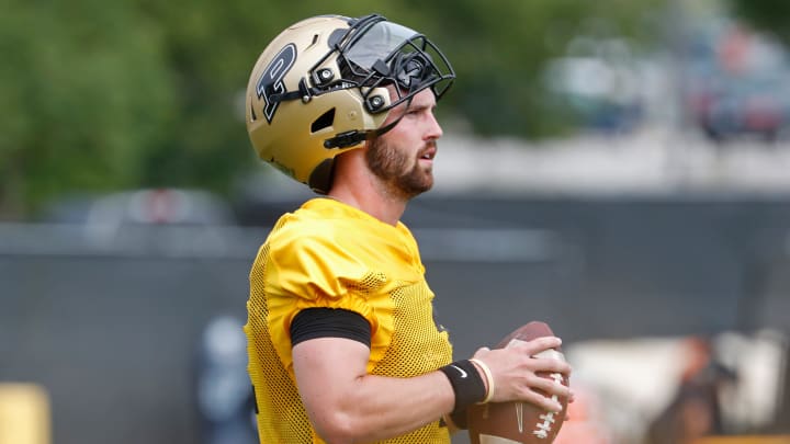 Purdue Boilermakers quarterback Hudson Card holds onto a football 