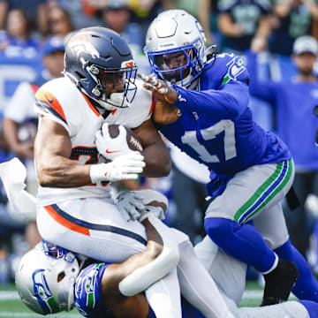 Sep 8, 2024; Seattle, Washington, USA; Seattle Seahawks defensive end Leonard Williams (99) and linebacker Jerome Baker (17) tackle Denver Broncos running back Audric Estime (23) for a loss during the third quarter at Lumen Field.