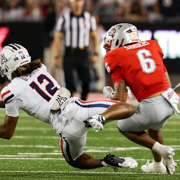 Aug 31, 2024; Tucson, Arizona, USA; Arizona Wildcats defensive back Genesis Smith (12) intercepts ball from New Mexico Lobos running back Eli Sanders (6) during second quarter at Arizona Stadium. Mandatory Credit: Aryanna Frank-Imagn Images