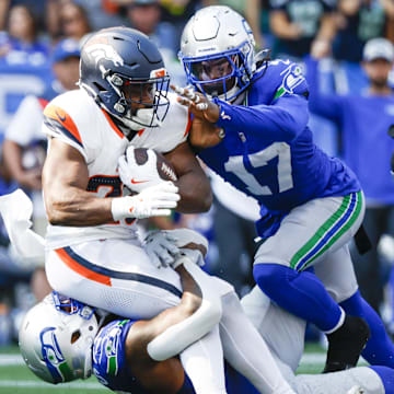 Sep 8, 2024; Seattle, Washington, USA; Seattle Seahawks defensive end Leonard Williams (99) and linebacker Jerome Baker (17) tackle Denver Broncos running back Audric Estime (23) for a loss during the third quarter at Lumen Field. Mandatory Credit: Joe Nicholson-Imagn Images