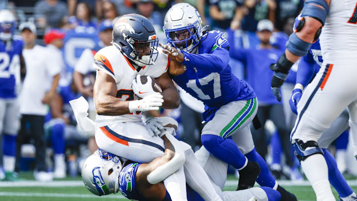 Sep 8, 2024; Seattle, Washington, USA; Seattle Seahawks defensive end Leonard Williams (99) and linebacker Jerome Baker (17) tackle Denver Broncos running back Audric Estime (23) for a loss during the third quarter at Lumen Field. Mandatory Credit: Joe Nicholson-Imagn Images