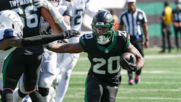Oct 5, 2025; East Rutherford, New Jersey, USA; New York Jets running back Breece Hall (20) carries the ball as he works around Dallas Cowboys safety Donovan Wilson (6) during the first half at MetLife Stadium. Mandatory Credit: Robert Deutsch-Imagn Images