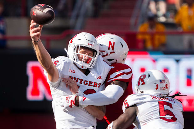 Rutgers quarterback Athan Kaliakmanis (16) throws as he is hit by Nebraska linebacker Vincent Shavers Jr. (1).