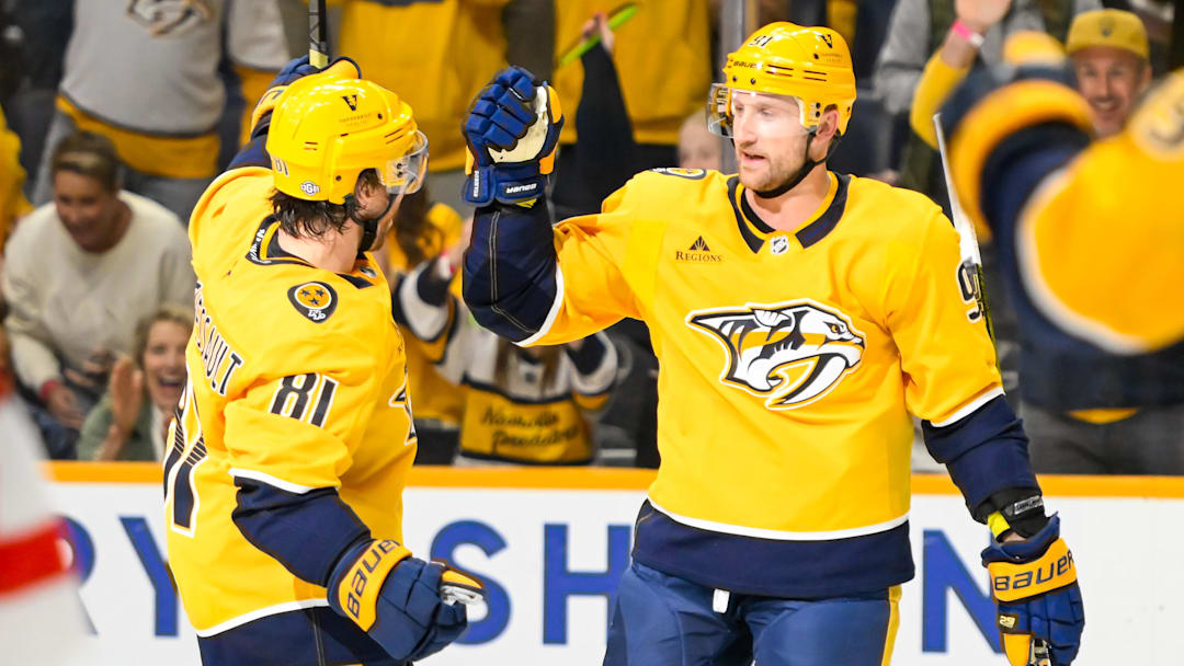 Oct 19, 2024; Nashville, Tennessee, USA;  Nashville Predators center Ryan O'Reilly (90) celebrates his goal with center Jonathan Marchessault (81) against the Detroit Red Wings Detroit Red Wings goaltender Cam Talbot (39) at Bridgestone Arena. Mandatory Credit: Steve Roberts-Imagn Images