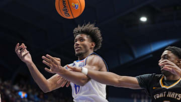 Oct 28, 2025; Lawrence, KS, USA; Kansas Jayhawks forward Samis Calderon (6) and Fort Hays State Tigers forward Dan Mukuna (0) fight for a rebound during the first half at Allen Fieldhouse. Mandatory Credit: Jay Biggerstaff-Imagn Images
