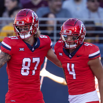 Nov 30, 2024; Tucson, Arizona, USA; Arizona Wildcats wide receiver Tetairoa McMillan (4) celebrates a touchdown with tight end Tyler Powell (87) against the Arizona State Sun Devils during the Territorial Cup at Arizona Stadium. Mandatory Credit: Mark J. Rebilas-Imagn Images