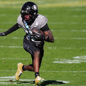 Nov 16, 2024; Boulder, Colorado, USA; Colorado Buffaloes wide receiver Travis Hunter (12) carries the ball in the second quarter against the Utah Utes at Folsom Field. Mandatory Credit: Ron Chenoy-Imagn Images