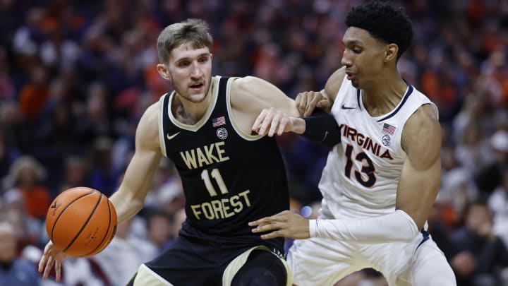 Feb 17, 2024; Charlottesville, Virginia, USA; Wake Forest Demon Deacons forward Andrew Carr (11) drives to the basket as Virginia Cavaliers guard Ryan Dunn (13) defends in the first half at John Paul Jones Arena. Mandatory Credit: Geoff Burke-USA TODAY Sports