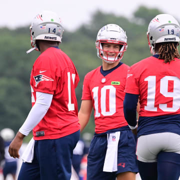 Jul 24, 2024; Foxborough, MA, USA;  New England Patriots quarterback Drake Maye (10) waits for drills to start with quarterback Jacoby Brissett (14) and quarterback Joe Milton III (19) training camp at Gillette Stadium. Mandatory Credit: Eric Canha-USA TODAY Sports