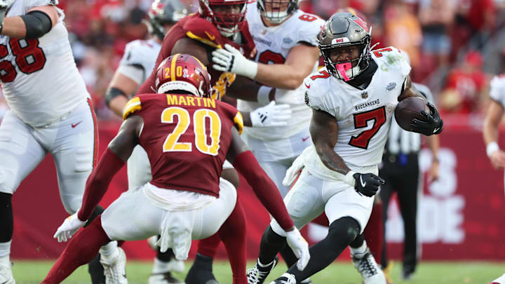 Sep 8, 2024; Tampa, Florida, USA;  Tampa Bay Buccaneers running back Bucky Irving (7) runs with the ball as Washington Commanders safety Quan Martin (20) defends during the second half at Raymond James Stadium. Mandatory Credit: Kim Klement Neitzel-Imagn Images