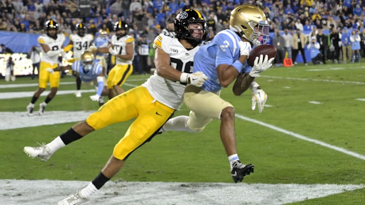 Nov 8, 2024; Pasadena, California, USA;   UCLA Bruins running back Anthony Frias II (29) is defended by Iowa Hawkeyes defensive back Sebastian Castro (29) as he makes a catch in the end zone for a touchdown in the first half at the Rose Bowl. Mandatory Credit: Jayne Kamin-Oncea-Imagn Images