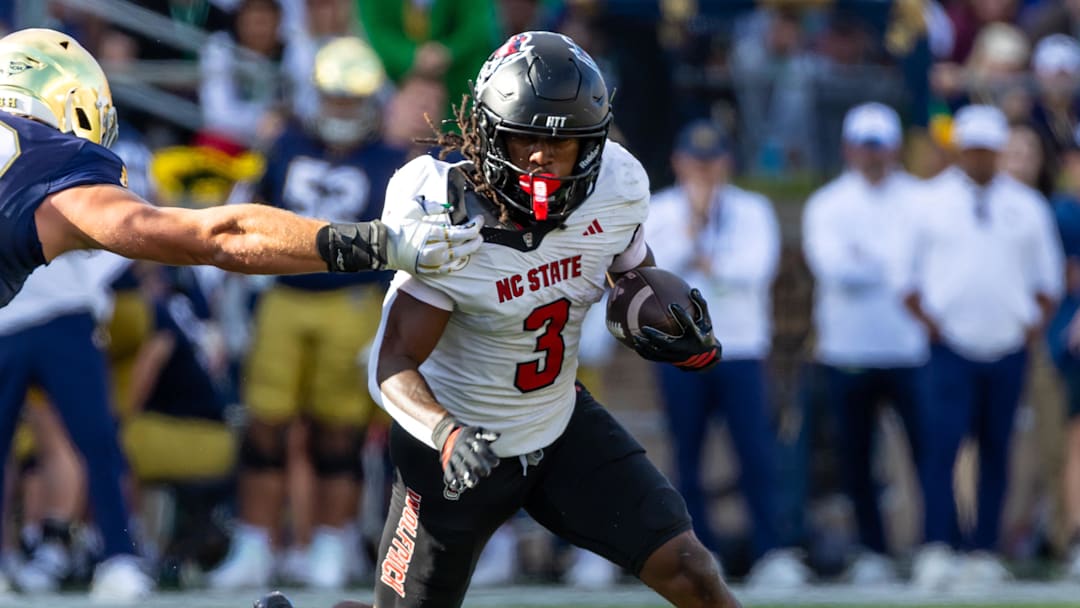 Oct 11, 2025; South Bend, Indiana, USA; NC State Wolfpack running back Hollywood Smothers (3) tries to break a tackle attempt by Notre Dame Fighting Irish linebacker Joshua Burnham (40) during the first half at Notre Dame Stadium. Mandatory Credit: Michael Caterina-Imagn Images