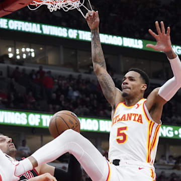 Apr 17, 2024; Chicago, Illinois, USA; Atlanta Hawks guard Dejounte Murray (5) dunks the ball on Chicago Bulls center Nikola Vucevic (9) during the second half during a play-in game of the 2024 NBA playoffs at United Center. Mandatory Credit: David Banks-Imagn Images