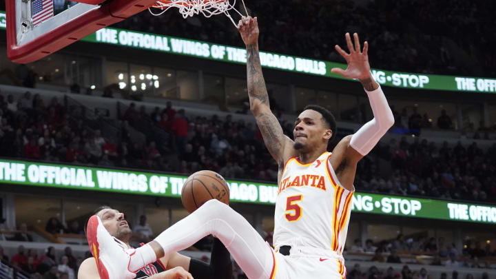 Apr 17, 2024; Chicago, Illinois, USA; Atlanta Hawks guard Dejounte Murray (5) dunks the ball on Chicago Bulls center Nikola Vucevic (9) during the second half during a play-in game of the 2024 NBA playoffs at United Center. Mandatory Credit: David Banks-USA TODAY Sports