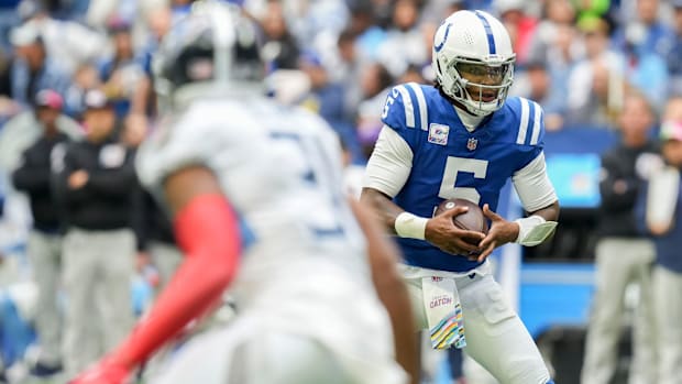 Colts quarterback Anthony Richardson (blue jersey; white helmet) gets ready to run with the football. 