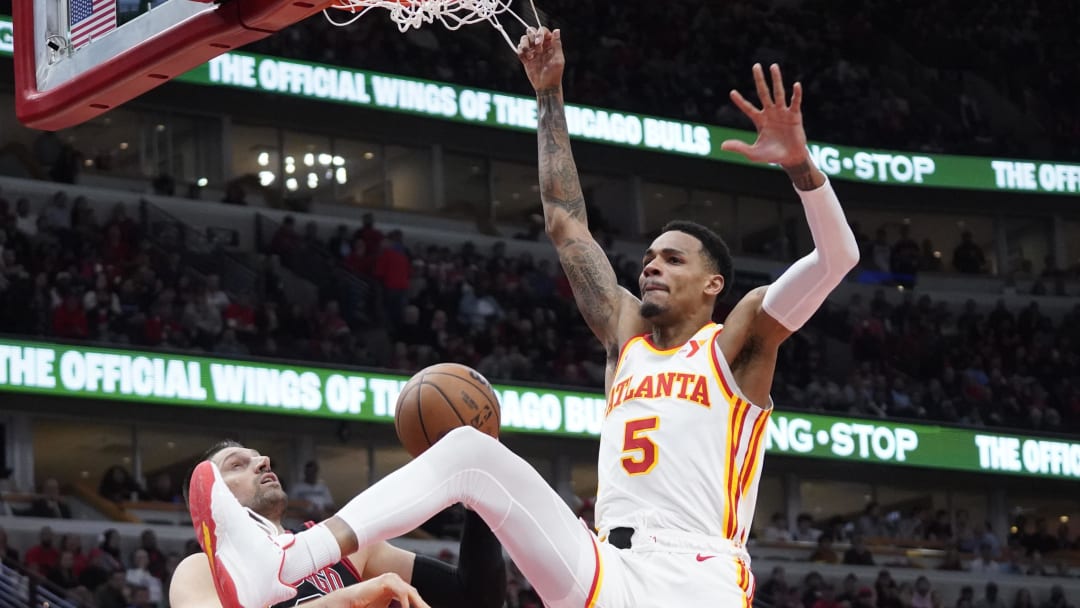 Apr 17, 2024; Chicago, Illinois, USA; Atlanta Hawks guard Dejounte Murray (5) dunks the ball on Chicago Bulls center Nikola Vucevic (9) during the second half during a play-in game of the 2024 NBA playoffs at United Center. 