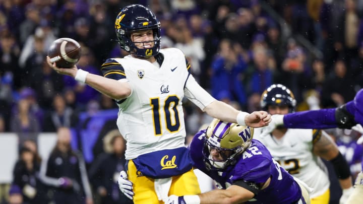 Sep 23, 2023; Seattle, Washington, USA; California Golden Bears quarterback Ben Finley (10) throws an interception while under pressure from Washington Huskies linebacker Carson Bruener (42) during the first quarter at Alaska Airlines Field at Husky Stadium.