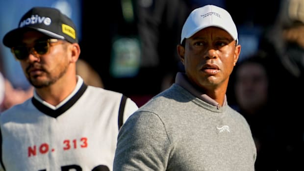 Tiger Woods and Jason Day check the scoreboard after finishing on no. 18 at the 2024 Masters.